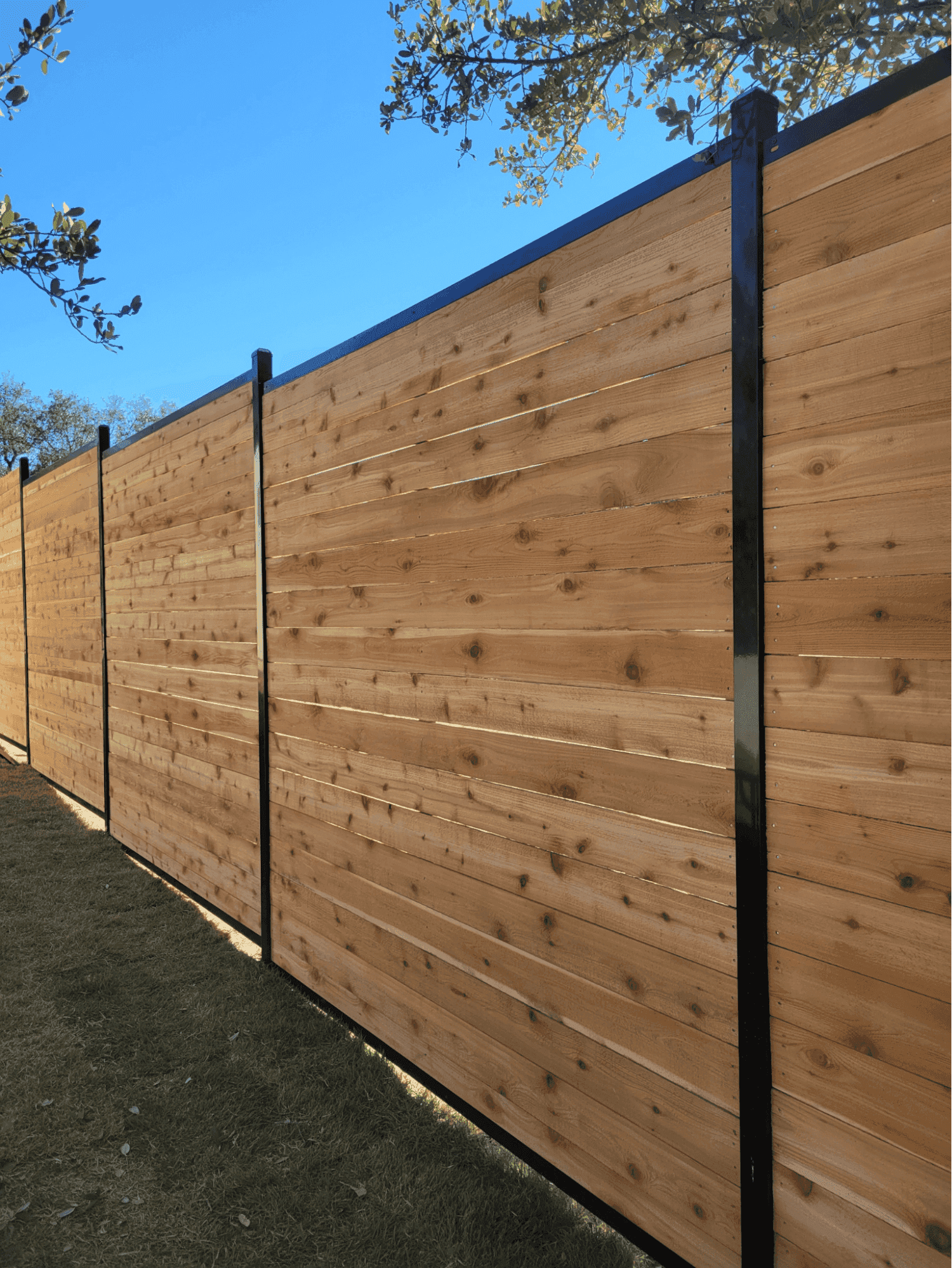 A close-up of heavy-duty, rust-resistant gate hardware installed securely on a solid wood fence post, illustrating the precision and quality construction that saves homeowners money on repairs.