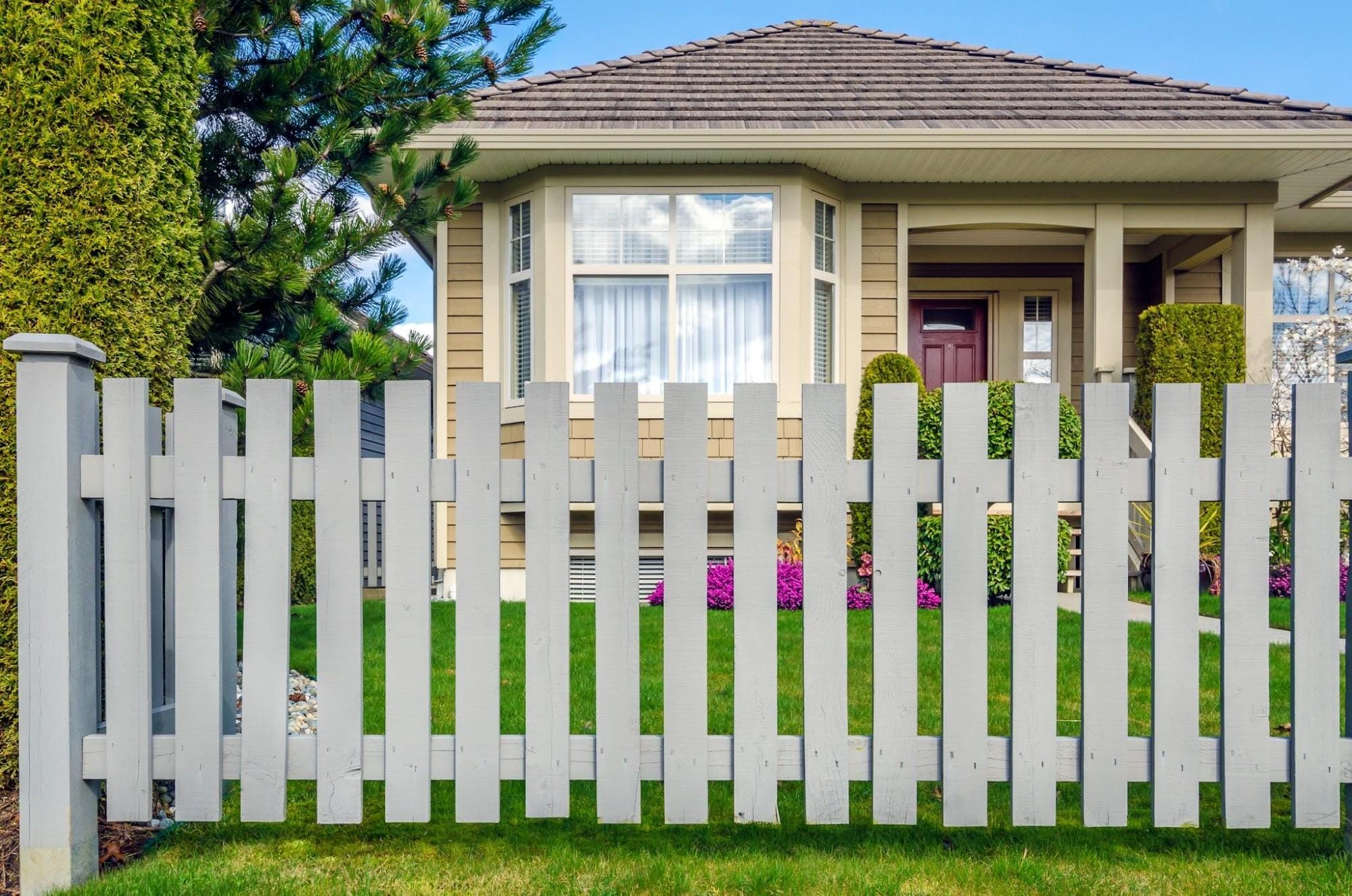 Professional Wood Privacy Fence Installation Georgetown A newly installed dark wood horizontal privacy fence along a lush green lawn, highlighting the clean lines and durable craftsmanship of a professional Georgetown fence company.
