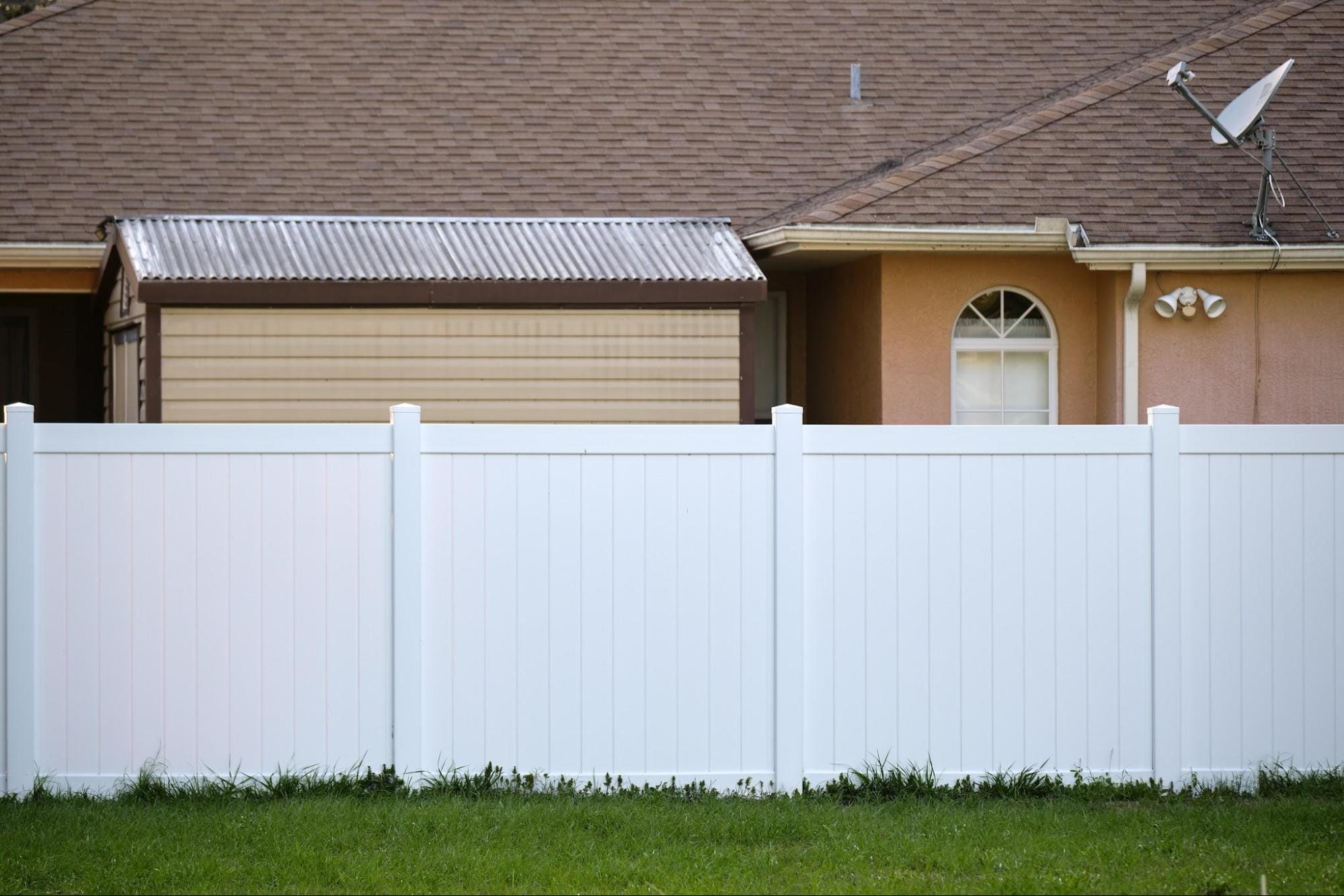 A clean, white privacy fence installed in a residential backyard, highlighting the importance of clear property line planning and professional fence installation in Georgetown.